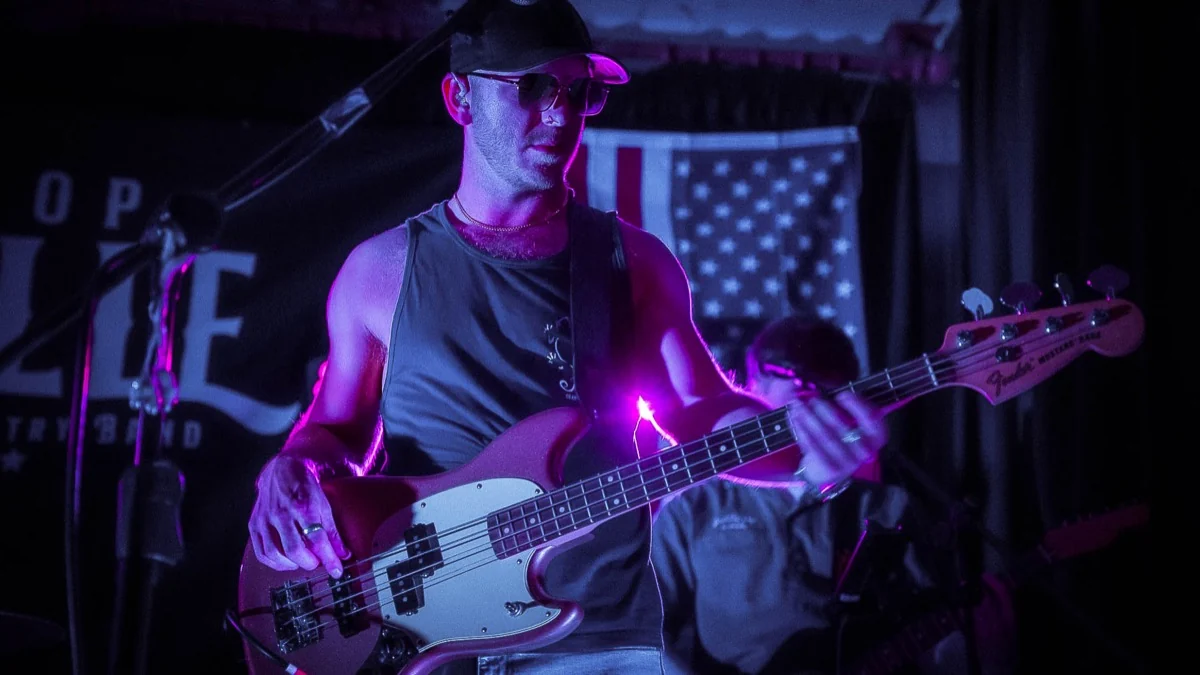 Next Stop Nashville bass player performing under purple lights