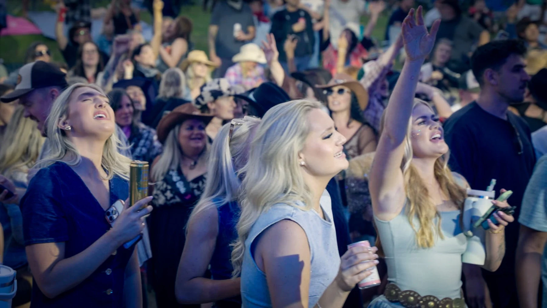 Country music fans singing along at a Next Stop Nashville show