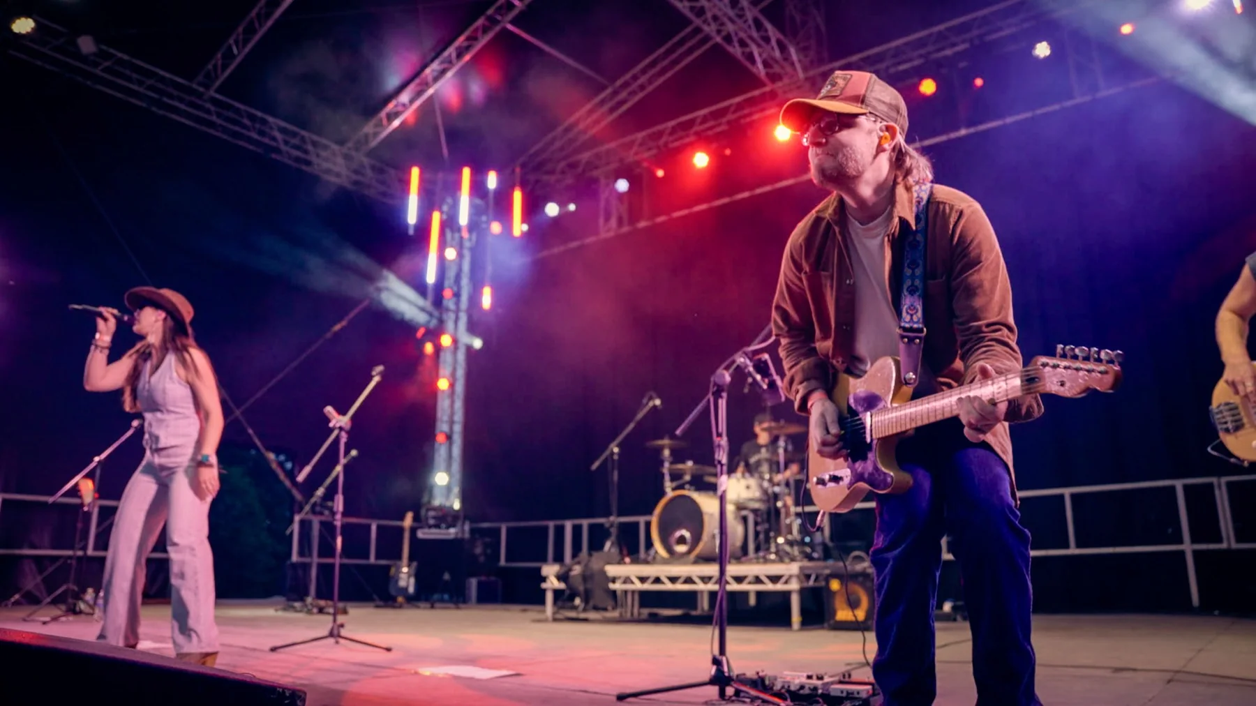 Next Stop Nashville guitarist performing on a large outdoor festival stage