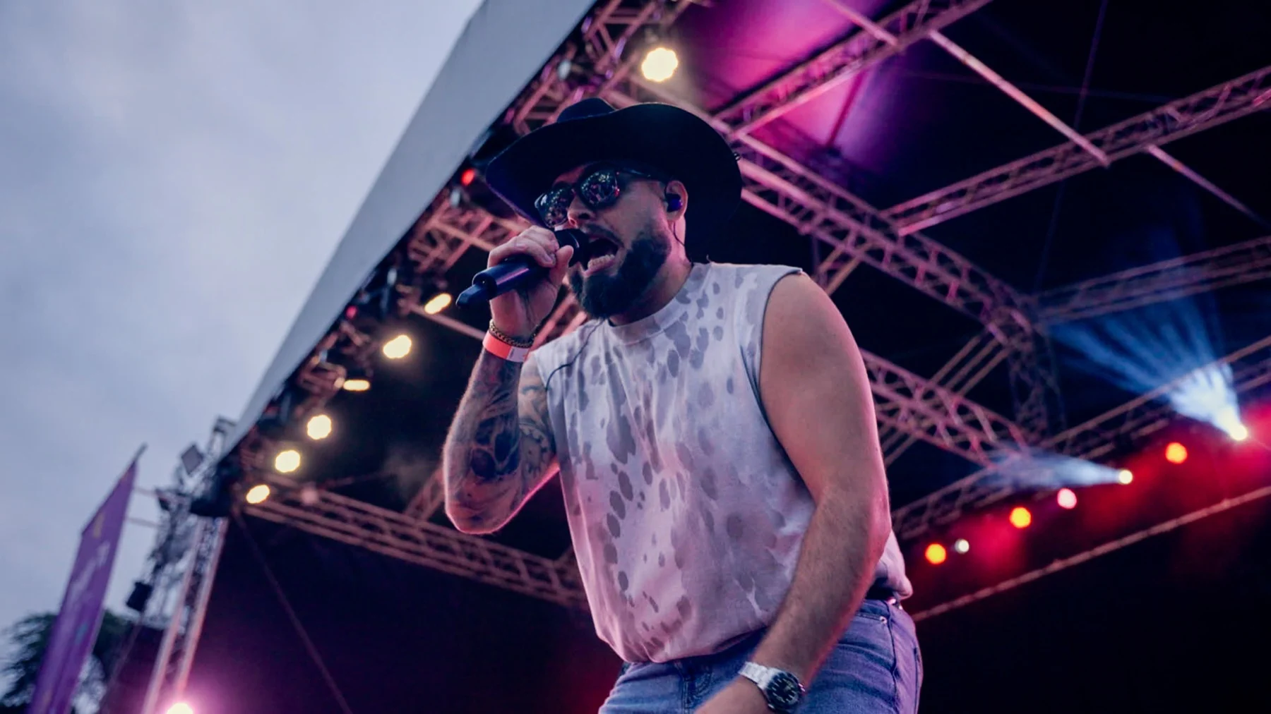 Next Stop Nashville lead vocalist singing from the front of a festival stage
